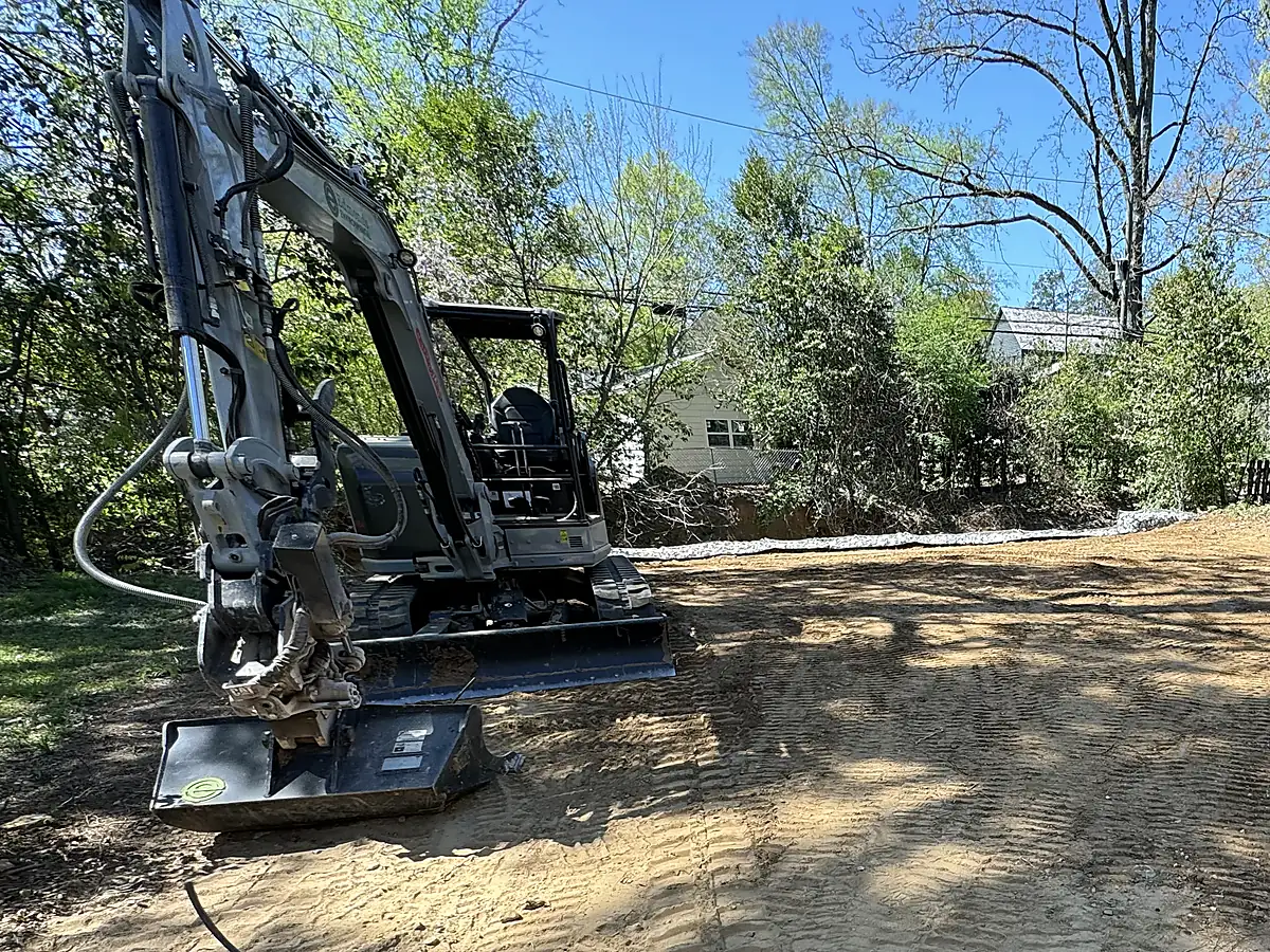 Excavator on freshly graded ground before lawn and planting installation