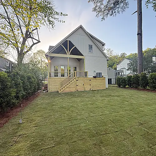 Rear elevation with new lawn, deck, and privacy planting completed
