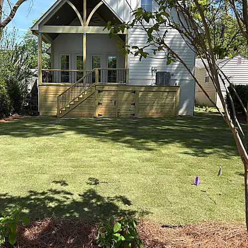 Fresh sod installation behind the home with new bed edges and shrub screening