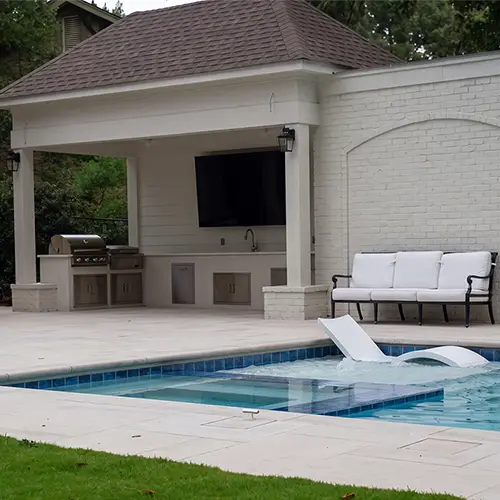 Pool and limestone deck beside the covered kitchen
