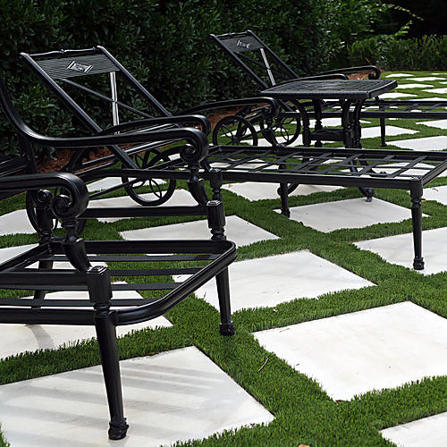Poolside lounge chairs on limestone and turf paving