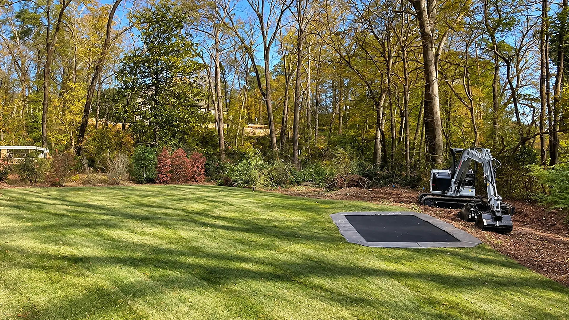 Steep wooded backyard before retaining wall construction and filling