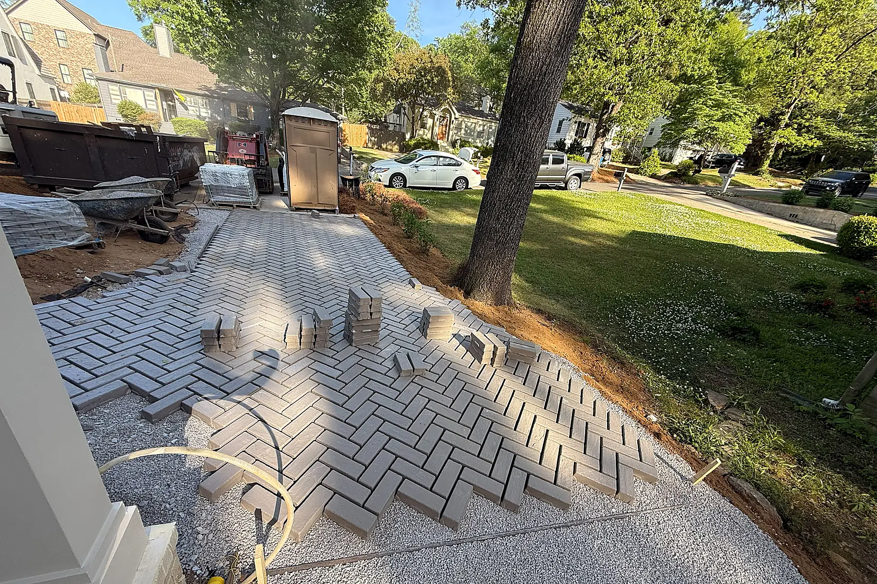 Curved paver edge and gravel margin wrapping around an existing tree