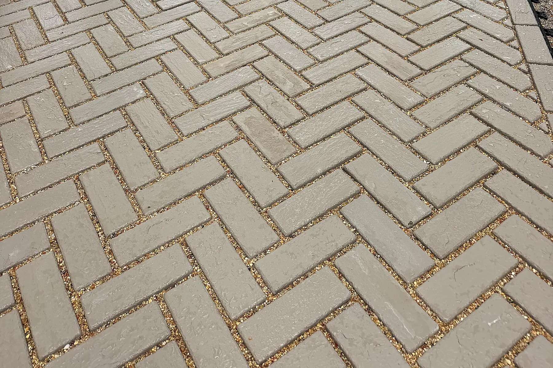 Close-up of gray brick pavers laid in a herringbone pattern